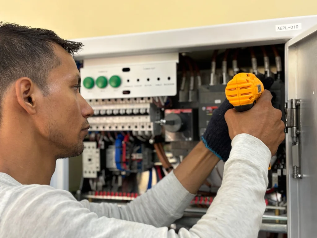 Commercial electrician working on an electrical panel in Oceanside, CA